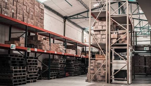 Karyawan toko menghitung stok barang di rak saat melakukan stock opname