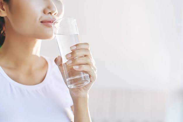 Seseorang minum air putih untuk memenuhi kebutuhan cairan setiap hari